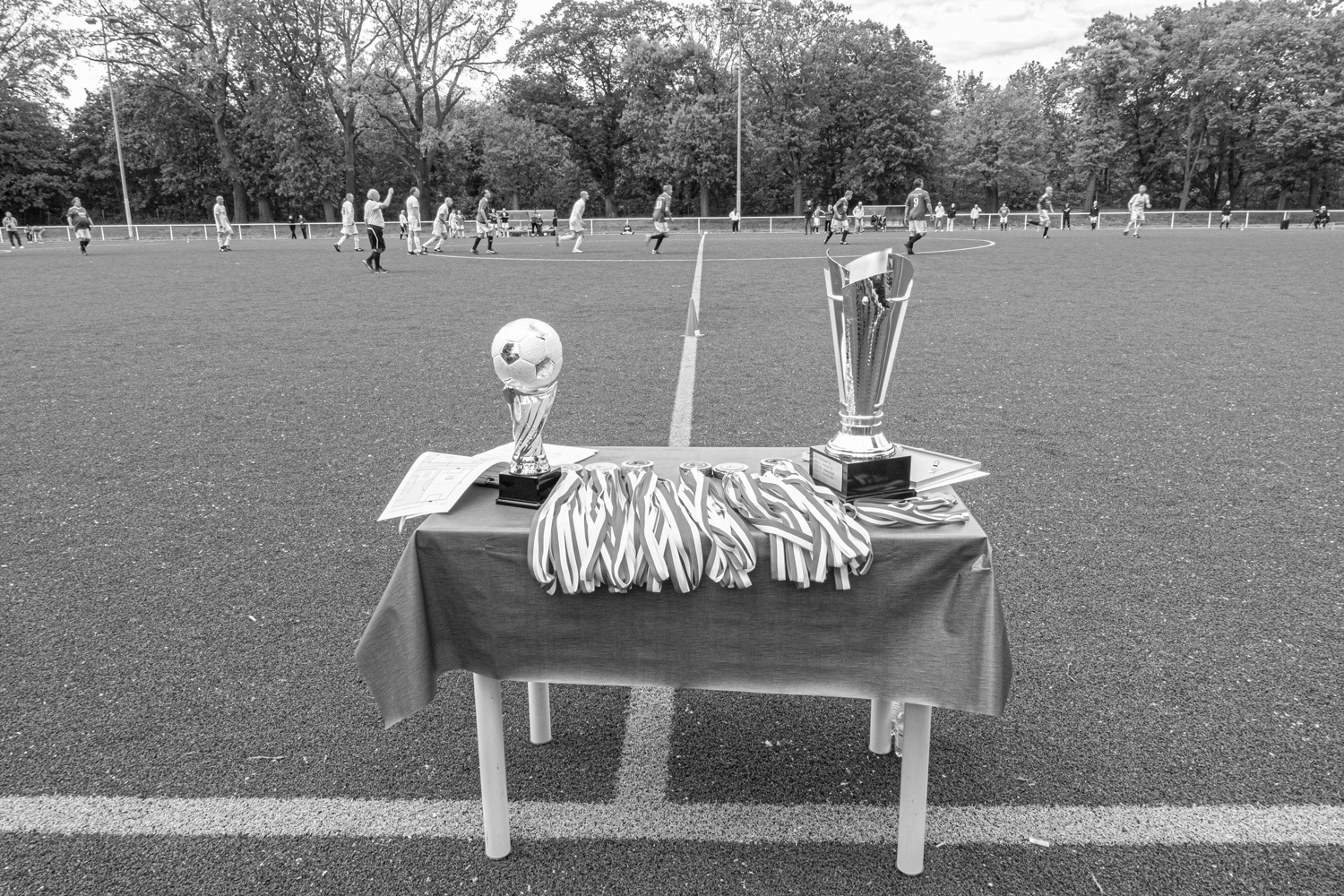 Pokal und Medaillen des defendo Pokal 2023 auf dem Tisch neben dem Fußballplatz in Berlin Lichterfelde